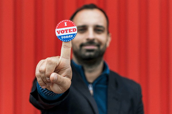 man holding an I voted button